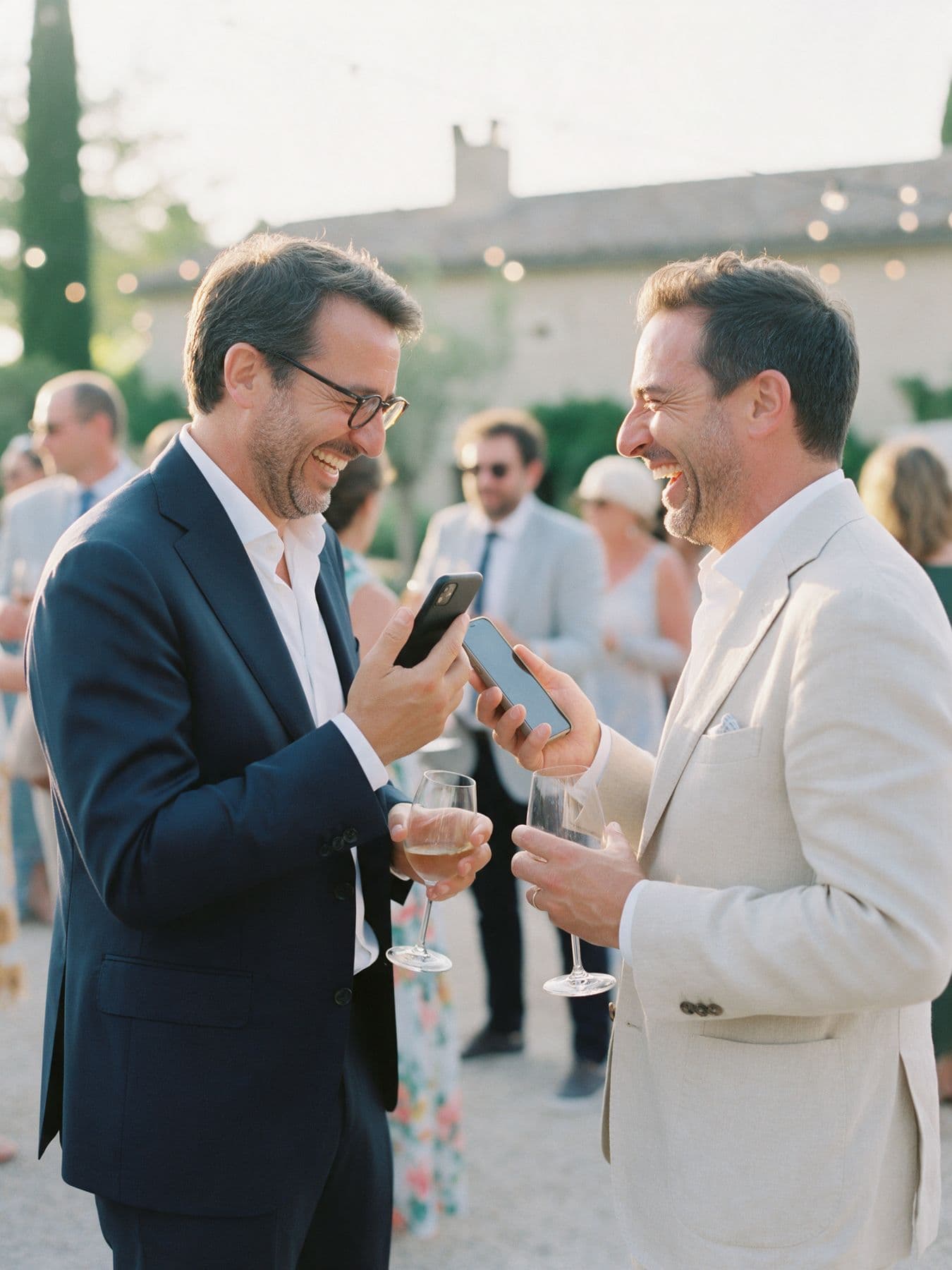 Deux invités qui viennent de se rencontrer rient en rapprochant leurs téléphones.