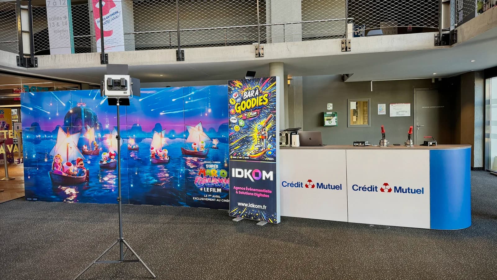 Le hall du Kinépolis de Belfort avant l'assemblée générale du Crédit Mutuel Belfort Centre : comptoir du bar à goodies aux couleurs de la caisse et studio photo